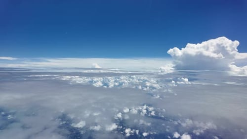 Aerial View of Fluffy Clouds and Clear Blue Sky