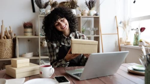 Small Business Owner Packing Her Handmade Product Into Cardboard Box