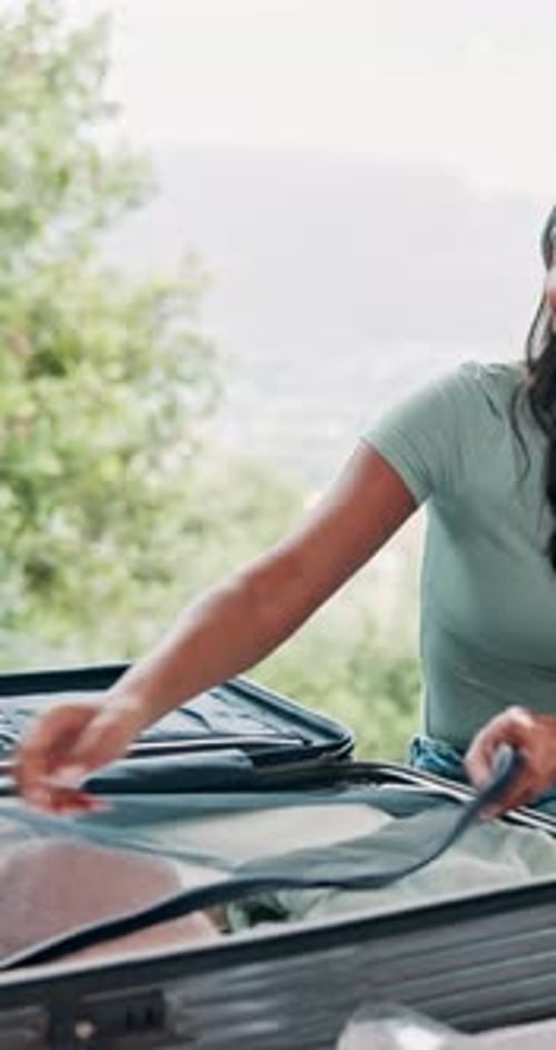Woman, headphones and packing luggage for travel in bedroom with clothes