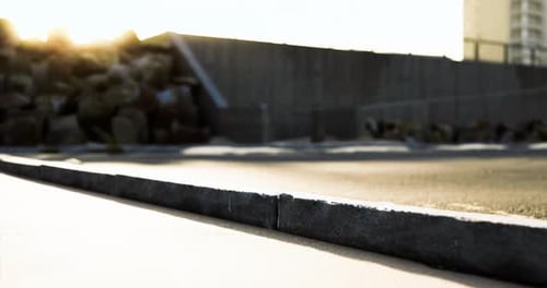 Sunset Casting Shadows on a Deserted Urban Pathway Near Rocks