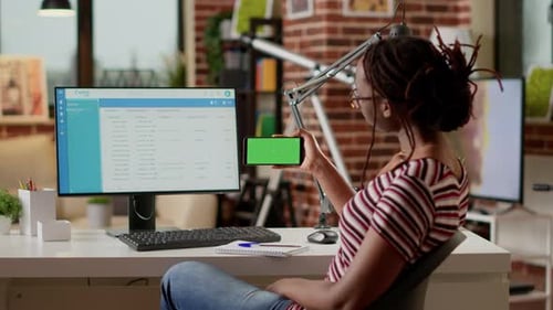 Woman Holding Green Screen Phone in Office Setting