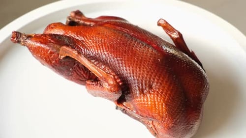 Whole Smoked Duck Platter Duck Carcass on a Cutting White Plate Rotating on a Turntable Grilled Wild