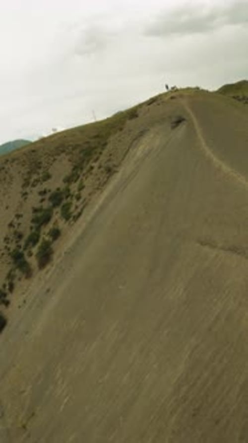 Dirt Track and Resting Motorcyclist on Hill Ridge