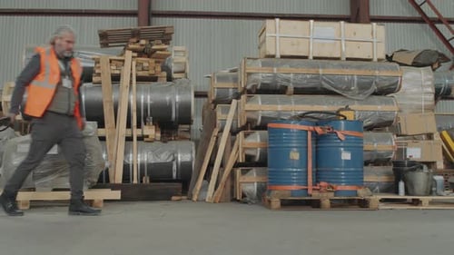 Foreman Pulling Pallet Truck with Shipments in Boxes while Working at Warehouse