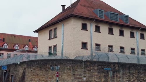 An Intriguing Historical Building Adorned with a Security Fence and Unique Rooftops in an Urban