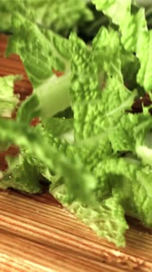 Pieces of Beijing Cabbage Fall on a Wooden Cutting boardFilmed is Slow Motion 1000 Fps