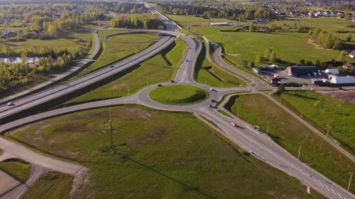 Aerial view capturing traffic circulating roundabout and highway through Katlakalns, Riga, Latvia