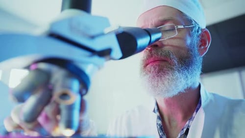 Scientist Analyzing Sample with Microscope in Laboratory