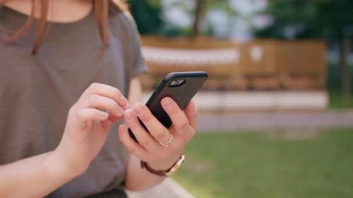 Woman Using Mobile Phone in Green Urban Environment