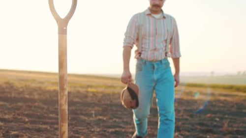 Portrait Shot of Attractive Caucasian Man in Cap Standing in Green Field Smiling Cheerfully to