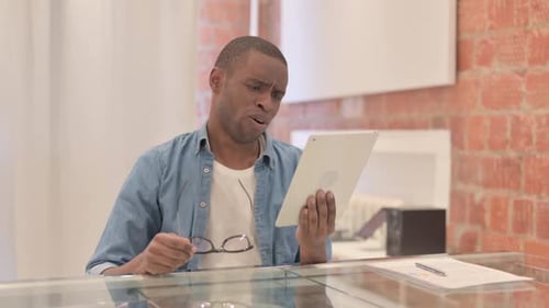 Man Frustrated While Using Tablet Device Indoors