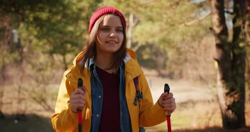 Backpacker Hiker Girl with Hiking Poles Walking Between Trees in a Mountain Forest Hispanic Teenager