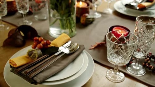 Thanksgiving table decorations with plates, cutlery, candles