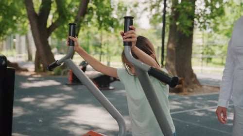 Girl Trains Happily with Mother Young Girl Works Out with Mom in Park Young Girl Practices Exercises