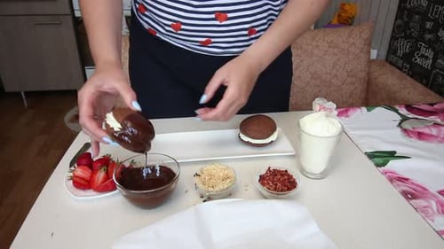 Person Dipping Chocolate Cake In Chocolate and Sprinkles
