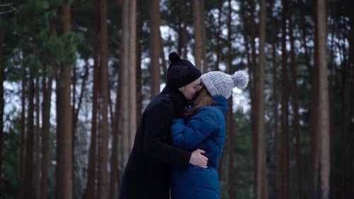 Young Couple Embracing in Winter Forest