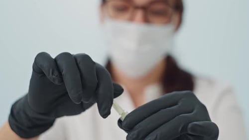 Medical Professional Prepares Hypodermic Needle for Injection