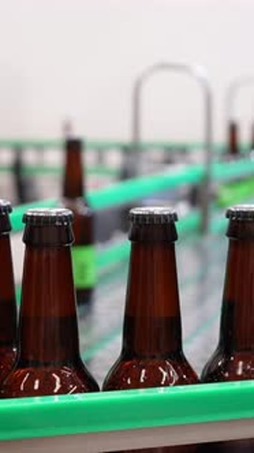 Bottles Proceeding Along Production Line in Factory Setting