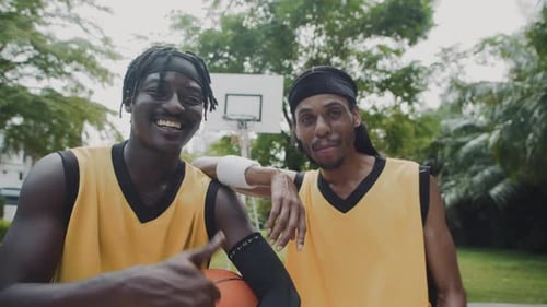 Smiling Men Pose with Basketball Outdoors