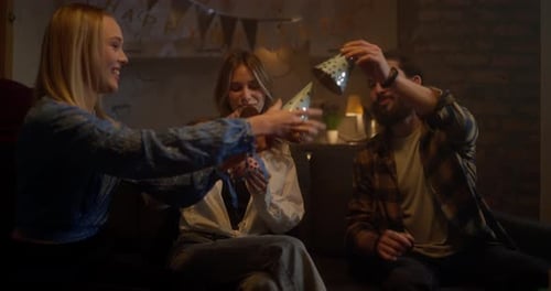 Happy Girl and Boyfriend Choose Holiday Caps Before the Start of a Party Between Friends at Home in