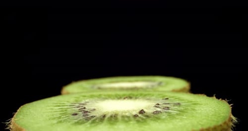 Juicy fresh kiwi fruit cut in half super close up shoot fly over 4k shoot on dark background HQ