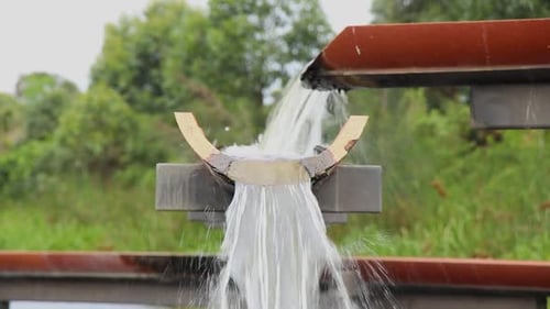 A raised multiple drainage system filling a wetlands lake with fast flowing water.