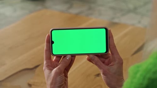 Woman's Hands Holding Phone with Green Screen