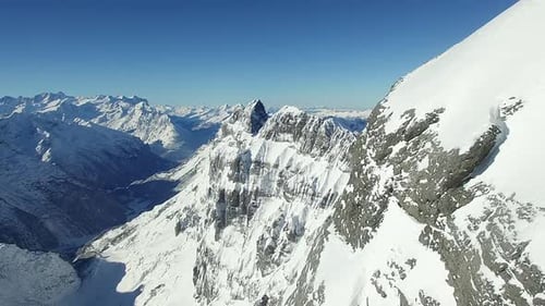 Snowcovered Alpine Mountain Range with Stunning Views for Hikers Under Clear Blue Sky