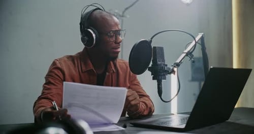 Expert Content Creator in Studio Records Podcast Using Prepared Notes and Professional Audio Gear