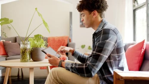 Biracial man working from home using tablet, slow motion