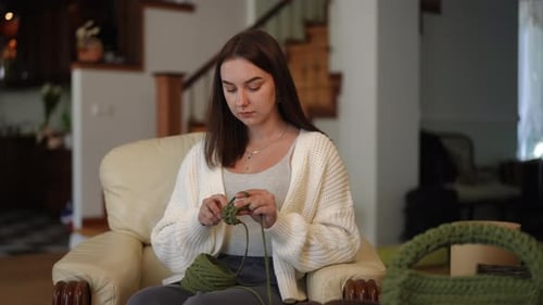 Woman Crocheting with Green Yarn at Home