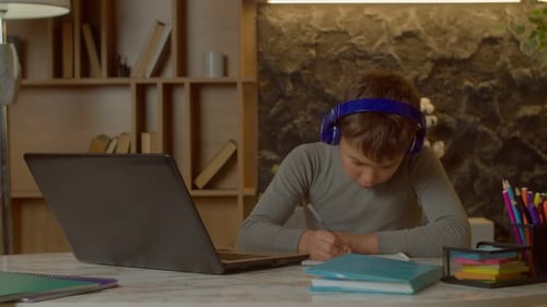 Boy Studying with Laptop and Headphones at Home