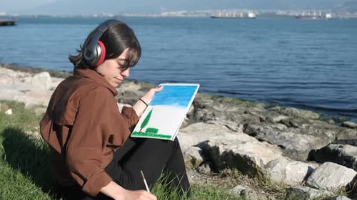 Young Adult Painting Picturesque Seascape on Sunny Day