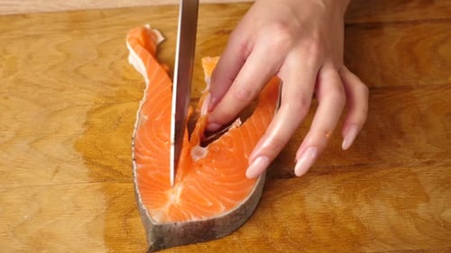 Cutting Salmon Steak on Wooden Cutting Board