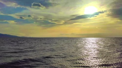 Spiegelung des Sonnenuntergangs auf bewölkter Meereslandschaft