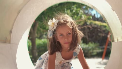 Child Girl Crawling in Pipe at Playground