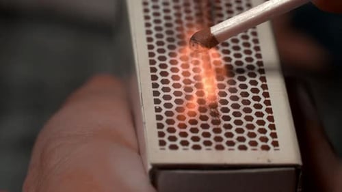 Lighting a Match with Matchbox Close Up