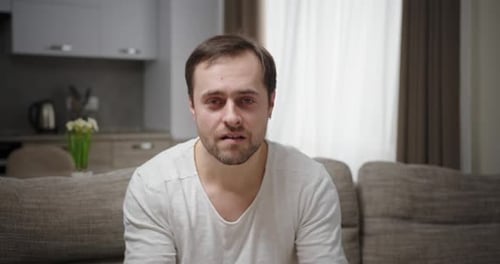 Dummer Mann macht Gesichter auf dem Sofa
