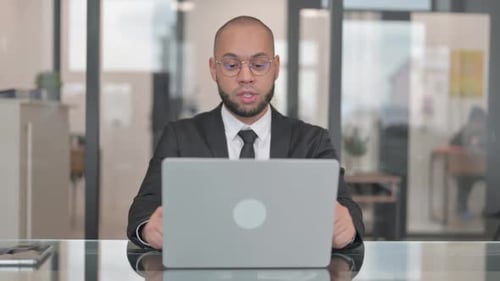Bearded Adult Video Conferencing on Laptop in Office