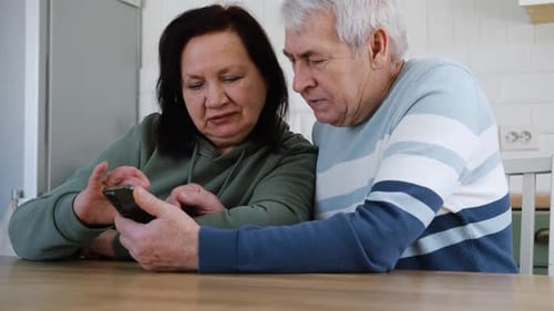 Mature Couple Looking at Mobile Phone Together