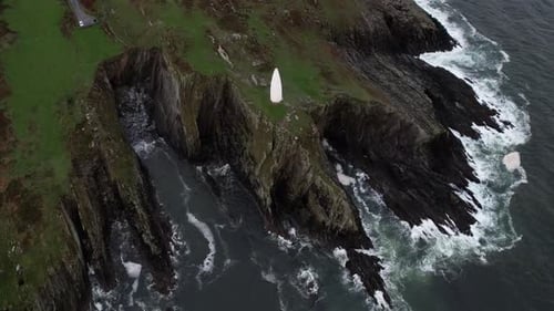Aerial view of Baltimore Beacon white stone tower on clifftop above Atlantic Ocean in County Cork, I