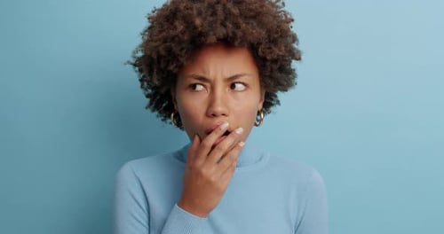 Astonished Embarrassed Dark Skinned Young Woman Stares In Disbelief Covers Mouth And Has Frighten...