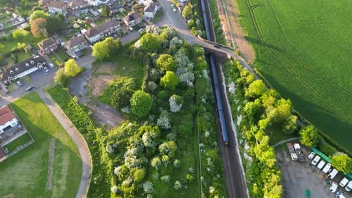 Imagens de drone capturando um trem partindo de uma estação de trem da vila