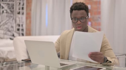 Excited Young Adult Celebrates Good News with Laptop