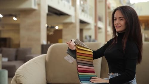 Woman Selecting Fabric Samples in a Furniture Showroom