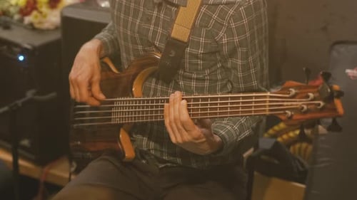Close Up of Bass Guitarist Playing Instrument