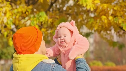 Cute Baby Daughter with Her Father in Autumn Park Happy Family