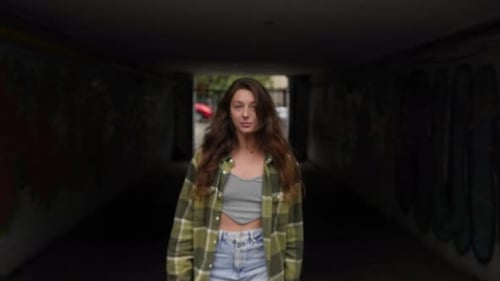 Young Woman Walking in Urban Graffiti Tunnel
