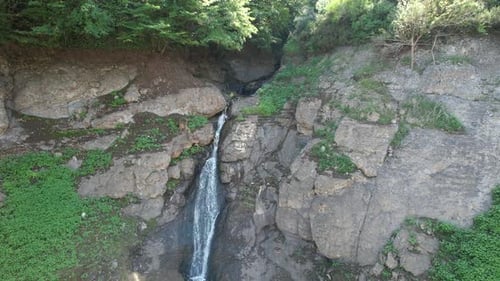Aerial View of Beautiful Waterfall Cascading Down Rocky Cliff