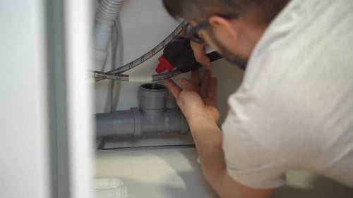 Plumber Hands Pour Remédio para o bloqueio de canos de esgoto na pia da cozinha
